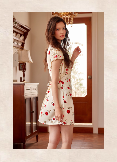 Standing sideways in a floral puff-sleeve night dress tied at the waist, the model showcases a dreamy vintage silhouette in a cottagecore interior.
