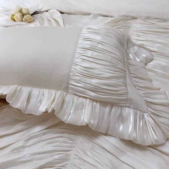 Elegant ivory bedding pillow with ruffled edges and soft pleated texture, styled in a romantic vintage bedroom aesthetic.