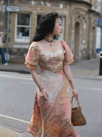 Model wearing a Romantic Fairytale vintage-inspired floral maxi dress with puff sleeves, lace neckline, and corset waist, carrying a woven basket for a cottagecore fairycore princesscore look outdoors.