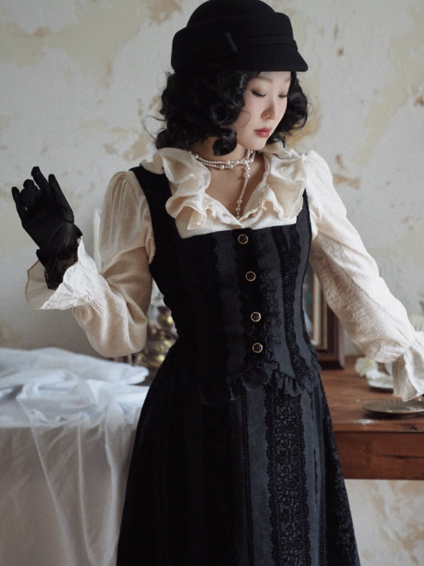 Close-up of the black lace-stripe pinafore dress bodice with gold-tone buttons and square neckline, styled with an ivory ruffle collar blouse for a vintage coquette cottagecore outfit.