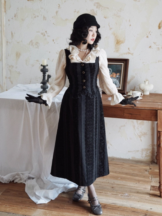 Model wearing a black lace-stripe vintage pinafore dress with button-front bodice, styled over an ivory ruffle-collar blouse in a Romantic Fairytale cottagecore room setting.