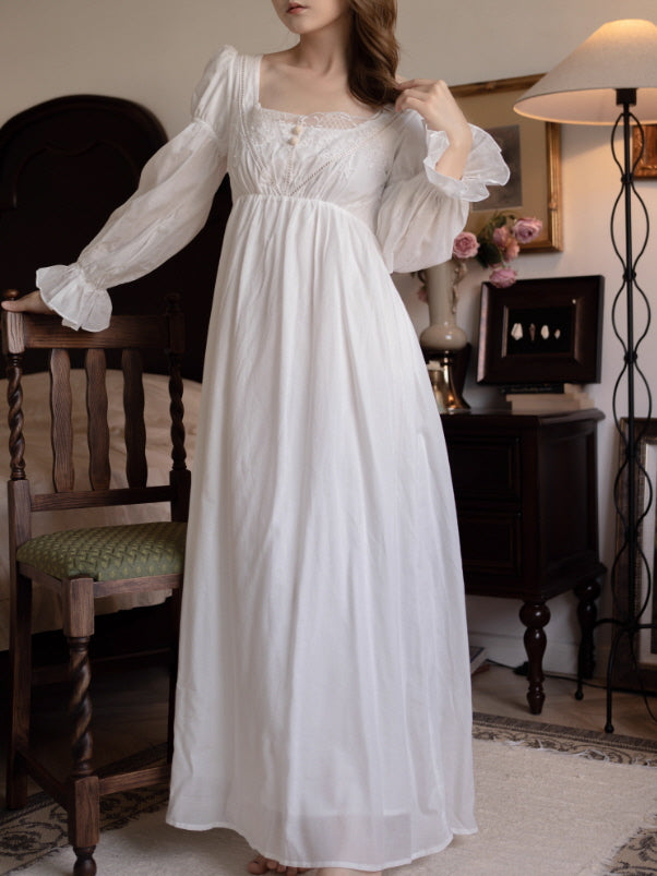 Model wearing an ivory square-neck lace embroidered long nightgown with puff sleeves and empire waist, romantic cottagecore princesscore loungewear in a vintage bedroom.