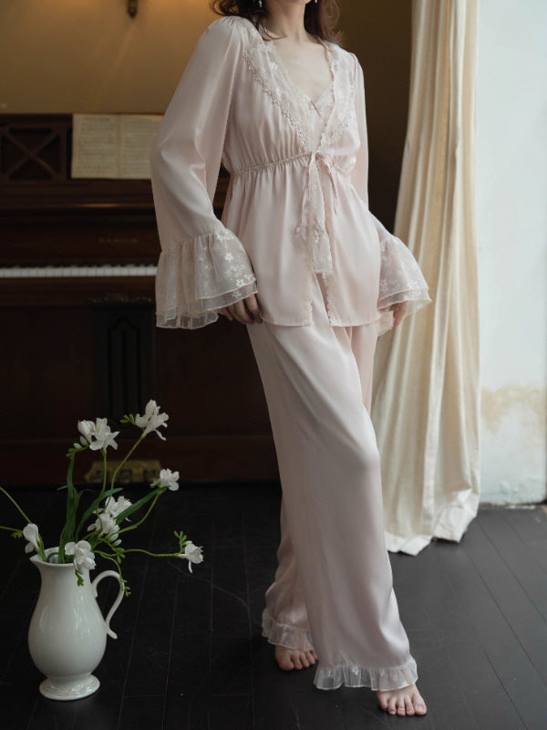 Model wearing a blush lace camisole and pants loungewear set with sheer lace robe draped over the arms, vintage princesscore cottagecore sleepwear in a warm piano room.