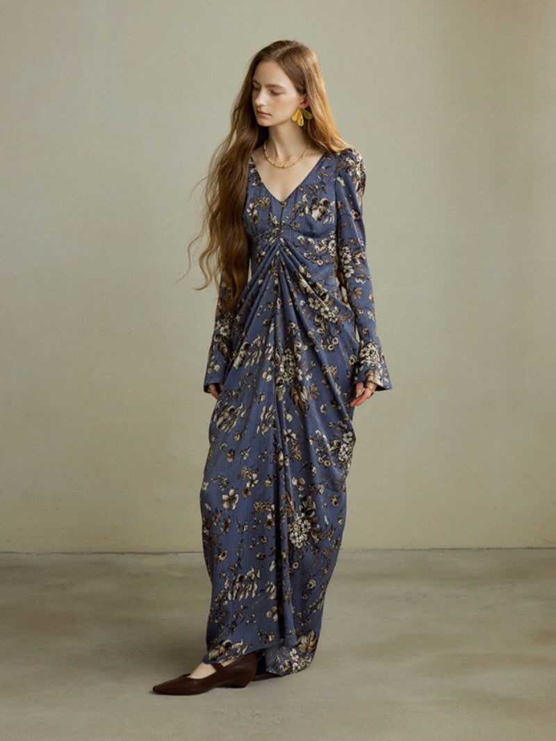 Full-length model wearing navy floral draped maxi dress with long sleeves and gathered waist detail, vintage-inspired cottagecore fairycore look for romantic occasions.