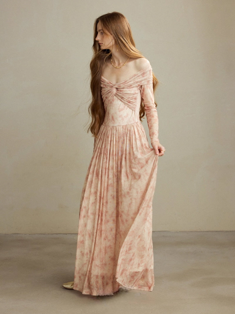 Model wearing a blush off-shoulder vintage long dress with a twisted draped bodice and flowing pleated skirt, styled in a soft cottagecore and fairycore aesthetic in a calm studio setting.