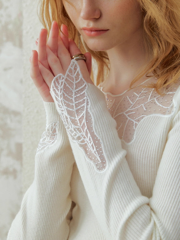 Close-up of an ivory knit top with delicate leaf lace embroidery on the neckline and sleeves, styled in a soft romantic fairycore look.