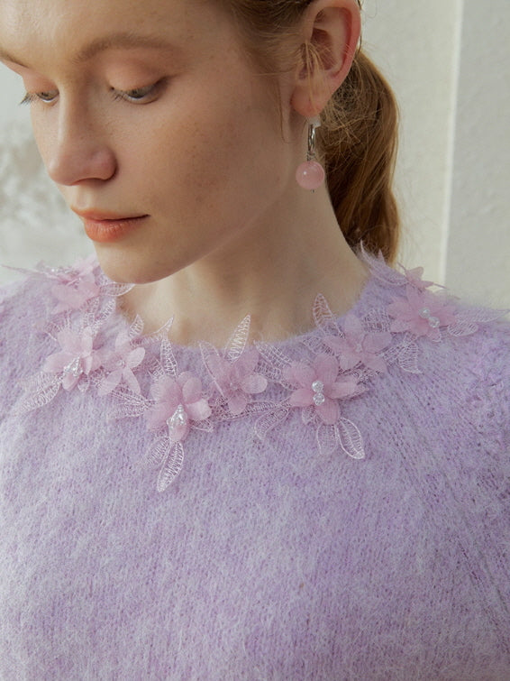 Close-up of a lilac floral appliqué knit top featuring delicate lace flowers and subtle bead accents, inspired by romantic fairycore and vintage style.