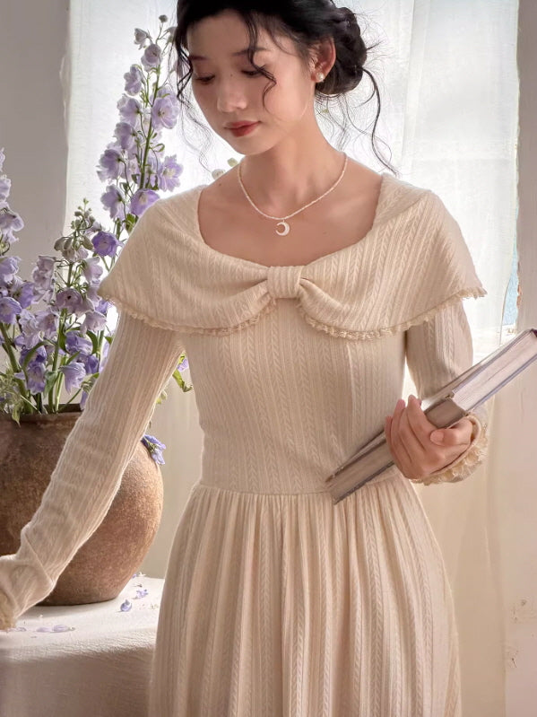 Close-up of an ivory vintage knit dress with a soft sailor collar and flowing silhouette, styled as a romantic princesscore and aesthetic outfit in natural light.