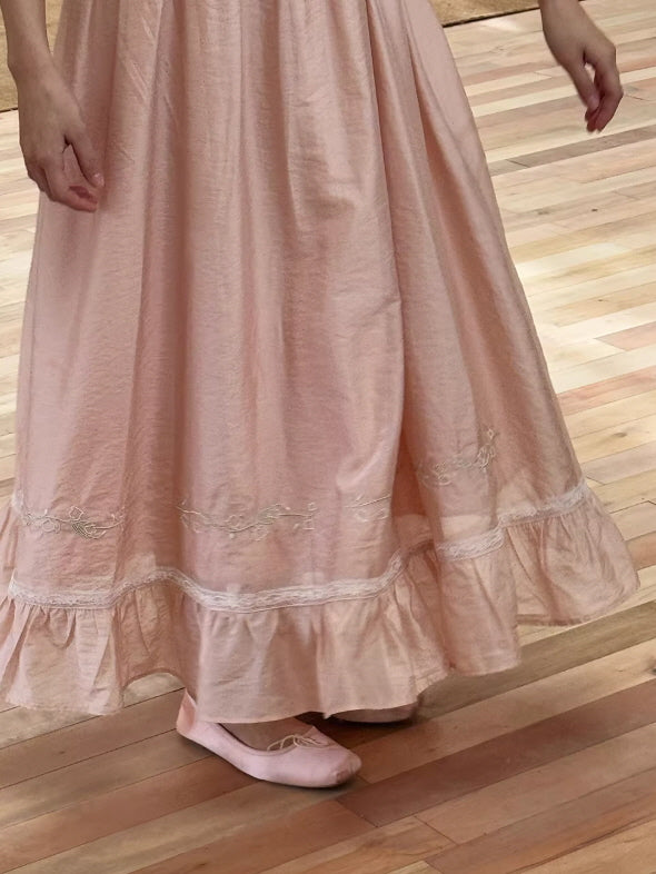 Close-up of a ruffled hemline with delicate lace trimmings and matching pink satin ballet flats, perfect for a coquette or balletcore look.