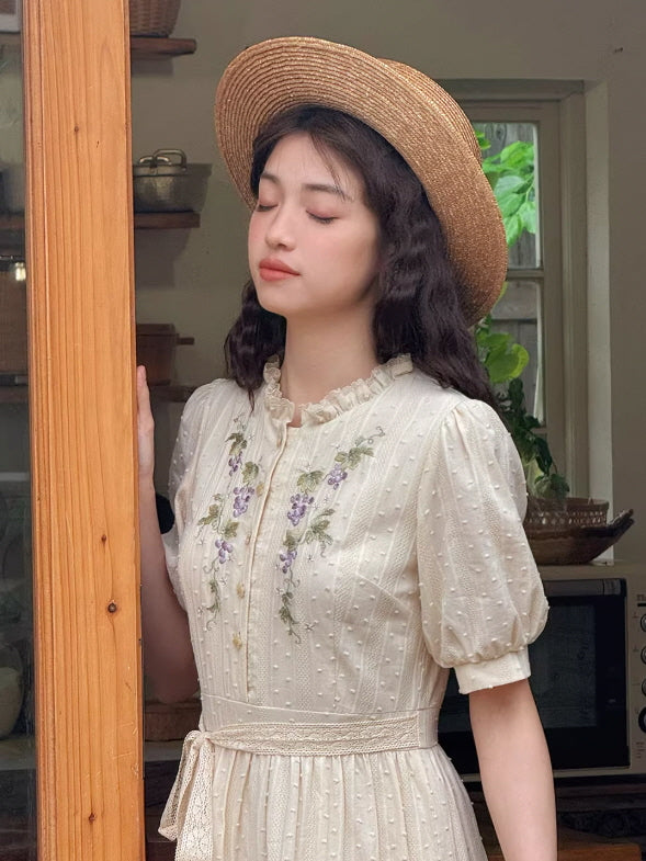 Side profile of a romantic fairycore dress with ruffled collar and puff sleeves against a nostalgic cottage backdrop.