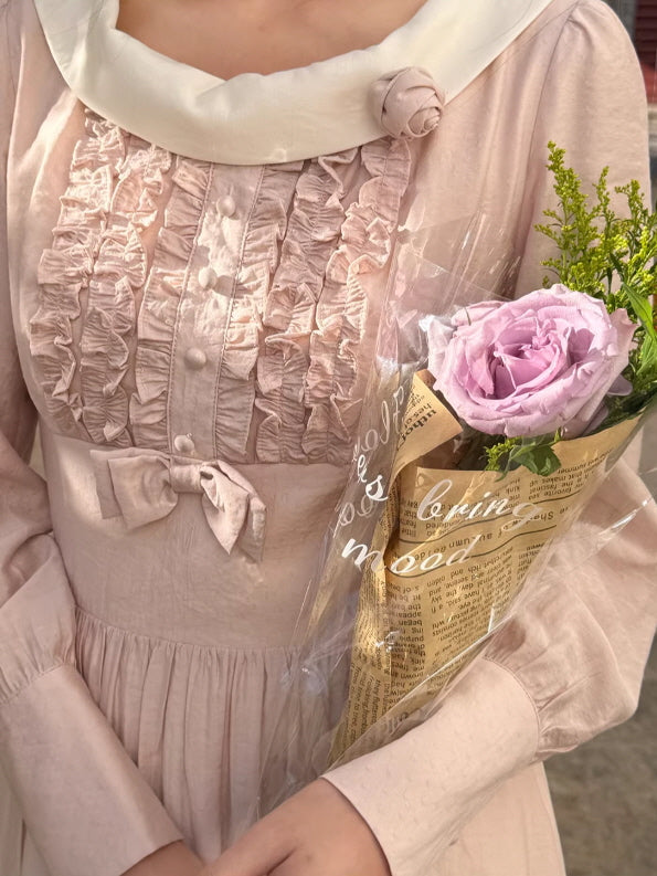 Soft romantic prairie dress with textured ruffle front, blush pink fabric and delicate bow waist, feminine cottagecore aesthetic