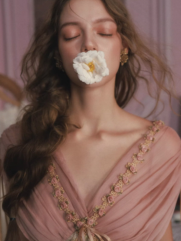 Close-up of floral embroidered neckline on blush pink chiffon romantic dress with soft vintage princess aesthetic