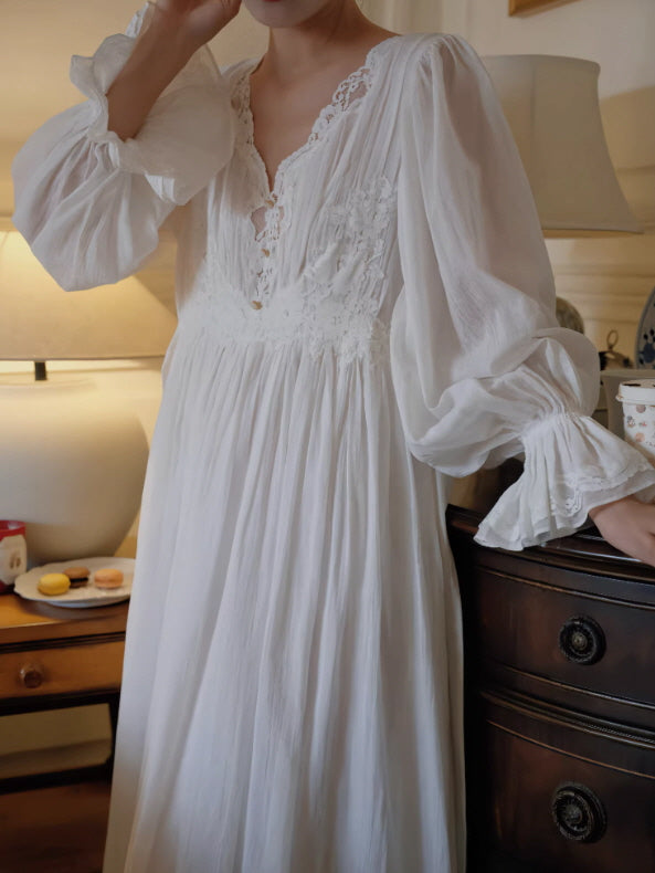 Close-up of lace neckline and embroidered bodice on white nightgown with airy long sleeves