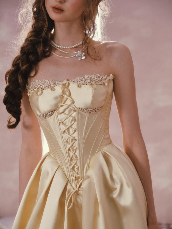 Champagne gold satin corset dress with lace trim and lace-up bodice, vintage princess aesthetic close-up