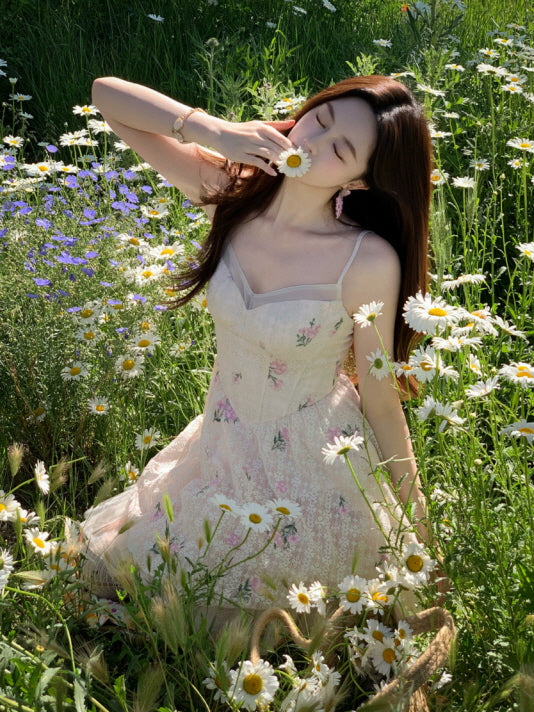Romantic ivory floral mini dress with delicate pink blossoms and tulle skirt, styled among daisies in a cottagecore meadow