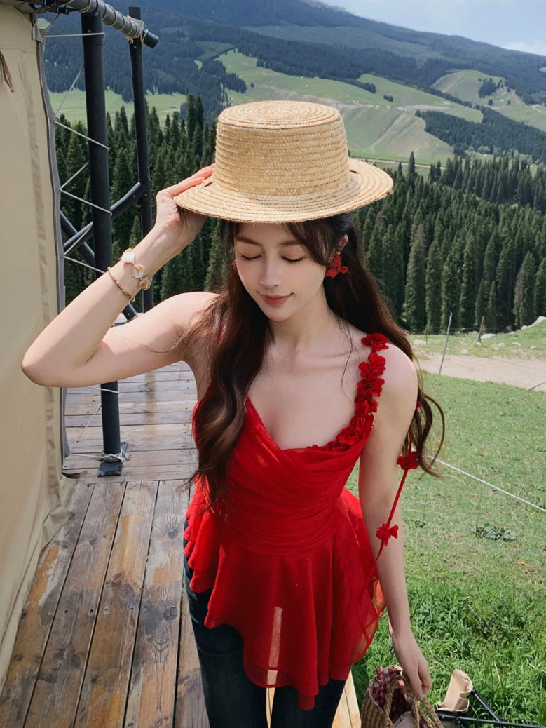 Romantic red ruched peplum top with delicate flower strap detail, styled with a straw hat and mountain view