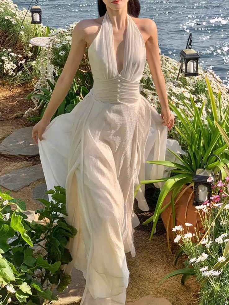 Romantic ivory halter dress with deep V neckline and pearl button waist by the seaside