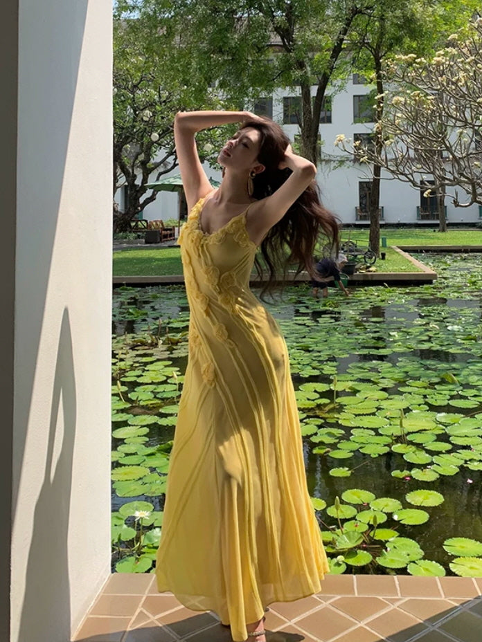 Yellow fairycore maxi dress with sheer floral details beside a lily pond