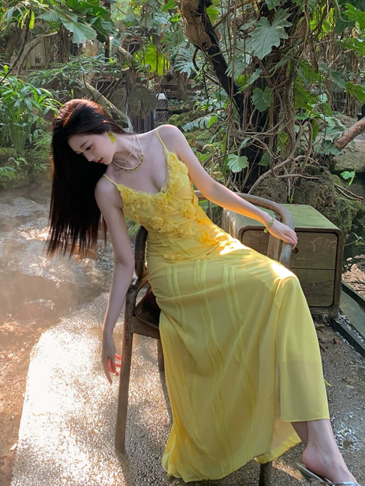 Yellow romantic maxi dress with rose appliques and delicate sheer fabric in a garden