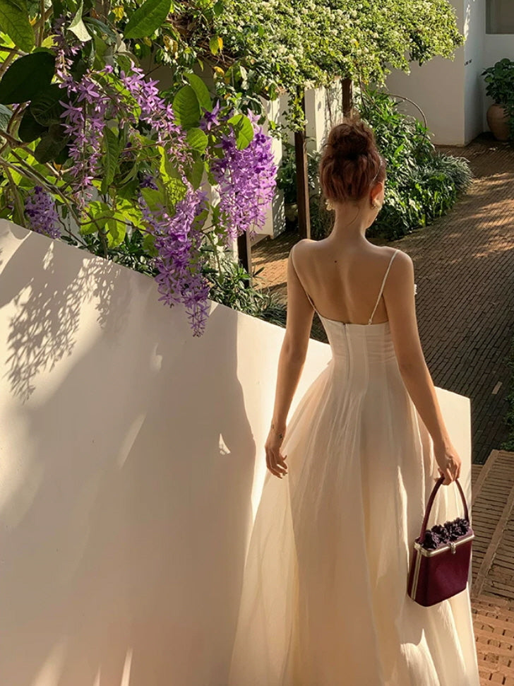 Ivory fairycore maxi dress with delicate straps and dreamy back view under purple flowers
