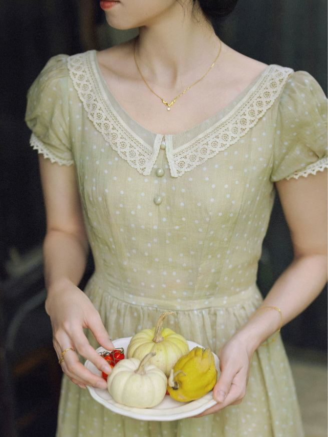 Close-up of sage green vintage dress with lace collar and puff sleeves
