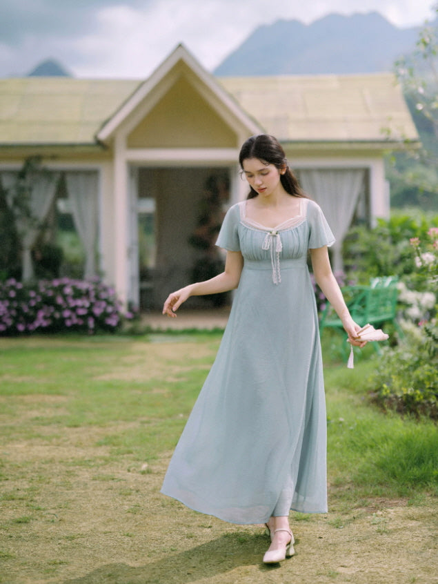 Vintage-inspired blue empire waist dress with flutter sleeves and flowing skirt