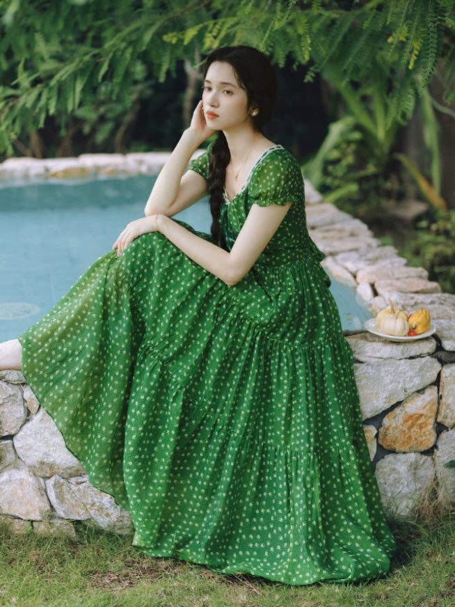 Romantic green cottagecore dress styled beside a garden pond