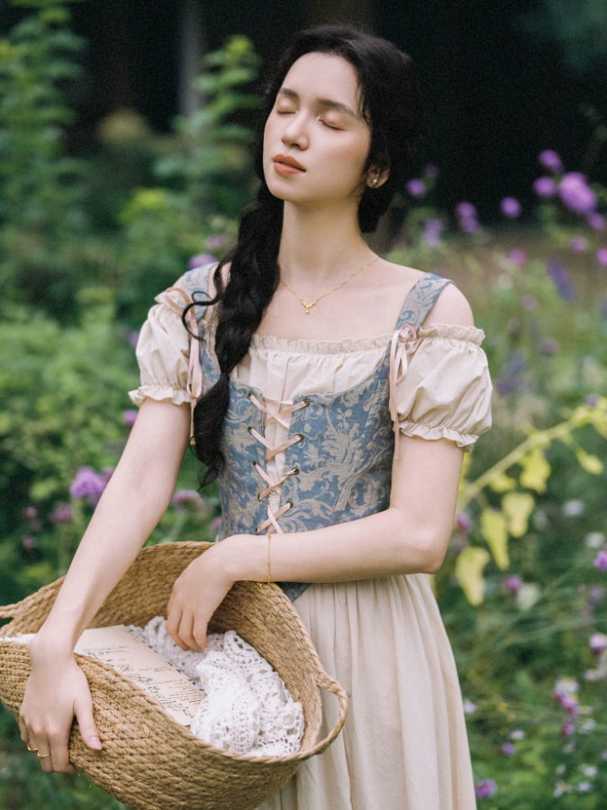 Romantic vintage cottagecore dress with off shoulder puff sleeves, blue brocade corset and woven basket accessory