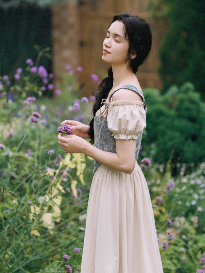 Side view of a vintage inspired maxi dress with blue patterned bodice, puff sleeves and graceful cottagecore silhouette