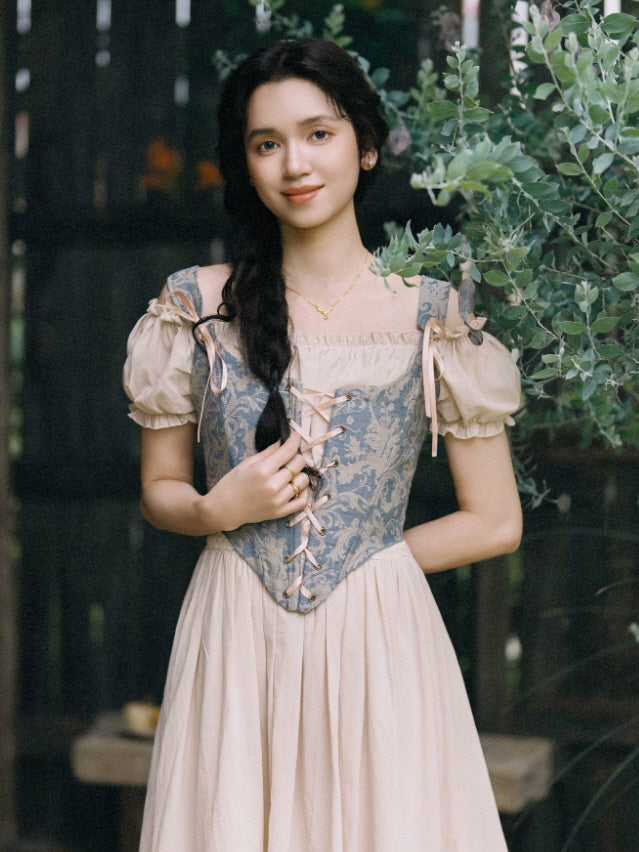 Elegant fairycore maxi dress featuring a blue jacquard corset top, blush ribbon lacing and a soft gathered skirt