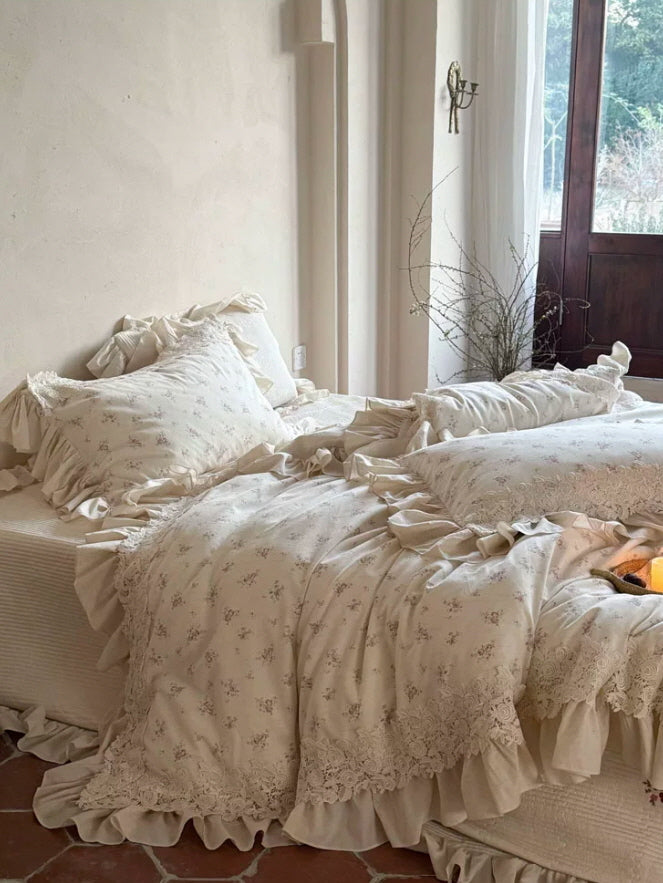 Fairycore inspired floral bedding with lace trim, romantic ruffled edges, and vintage cottage style in a light cream bedroom