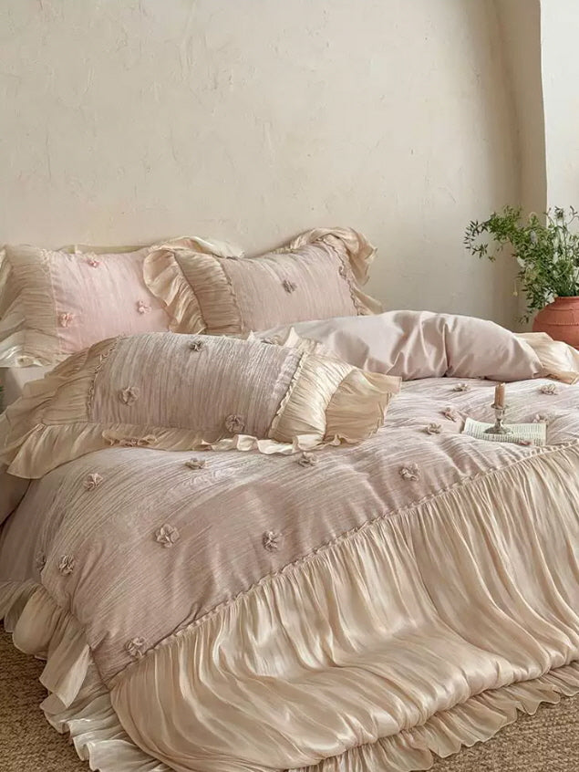 Romantic blush pink bedding set with satin ruffles, delicate floral appliques, and princesscore styling in a dreamy bedroom