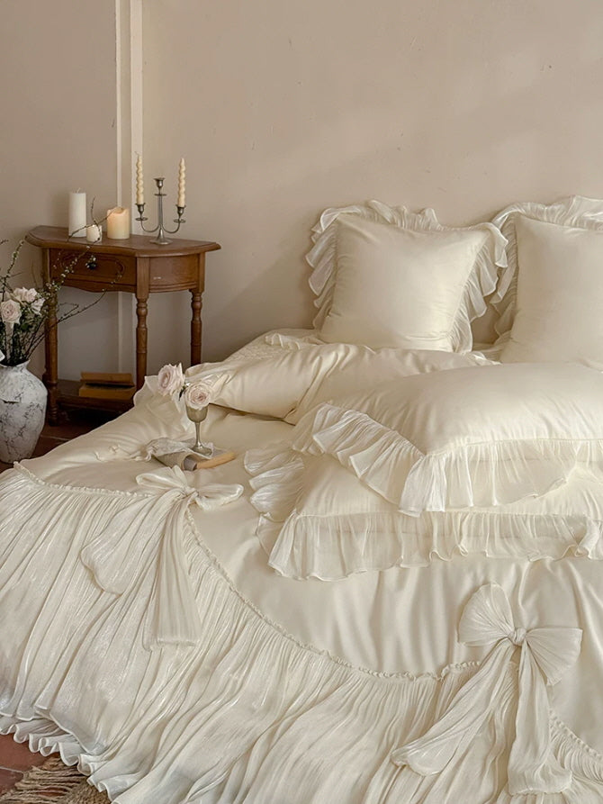 Ivory bow ruffle bedding set with flowing pleated trim in a romantic princesscore bedroom