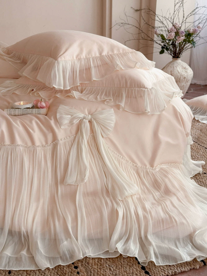 Romantic blush bedding set with cascading ivory ruffles and elegant decorative bow details