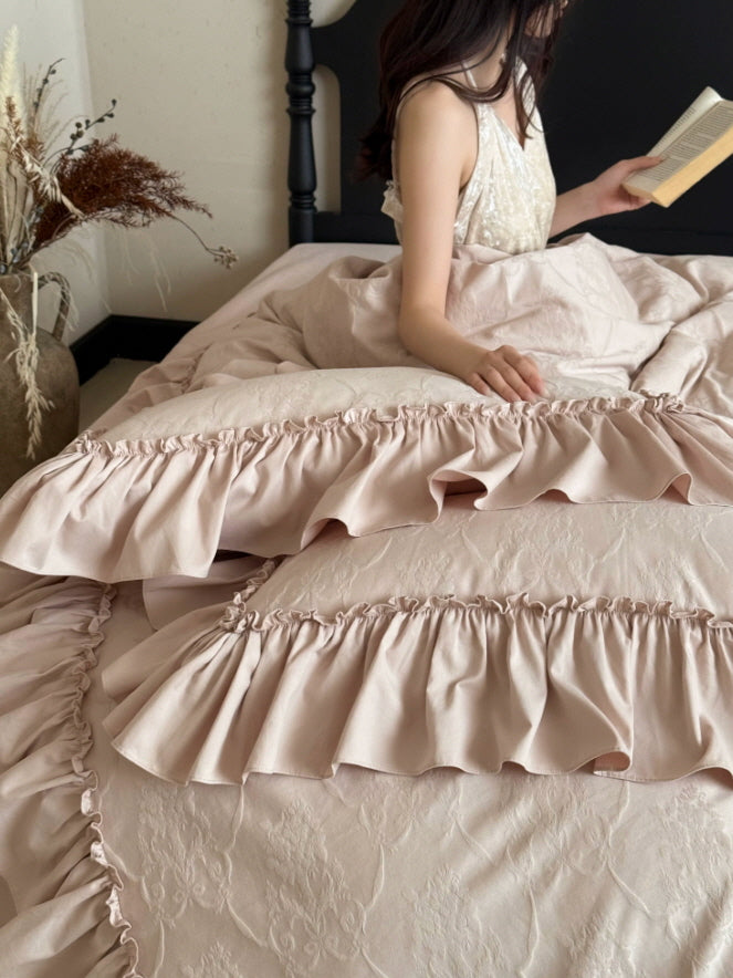 Romantic blush floral bedding with wide ruffled edges and dreamy vintage bedroom styling
