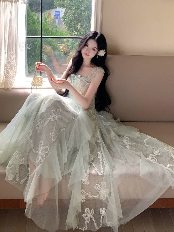 Romantic mint green princesscore dress with embroidered bows and flowing sheer tulle skirt by a sunny window