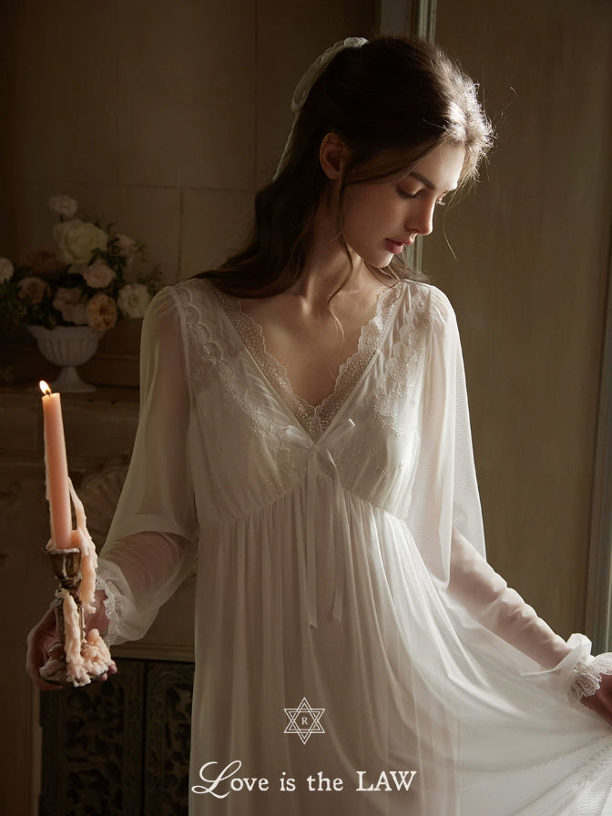 Close up of white lace nightgown with embroidered V neckline, bow accent and sheer sleeves