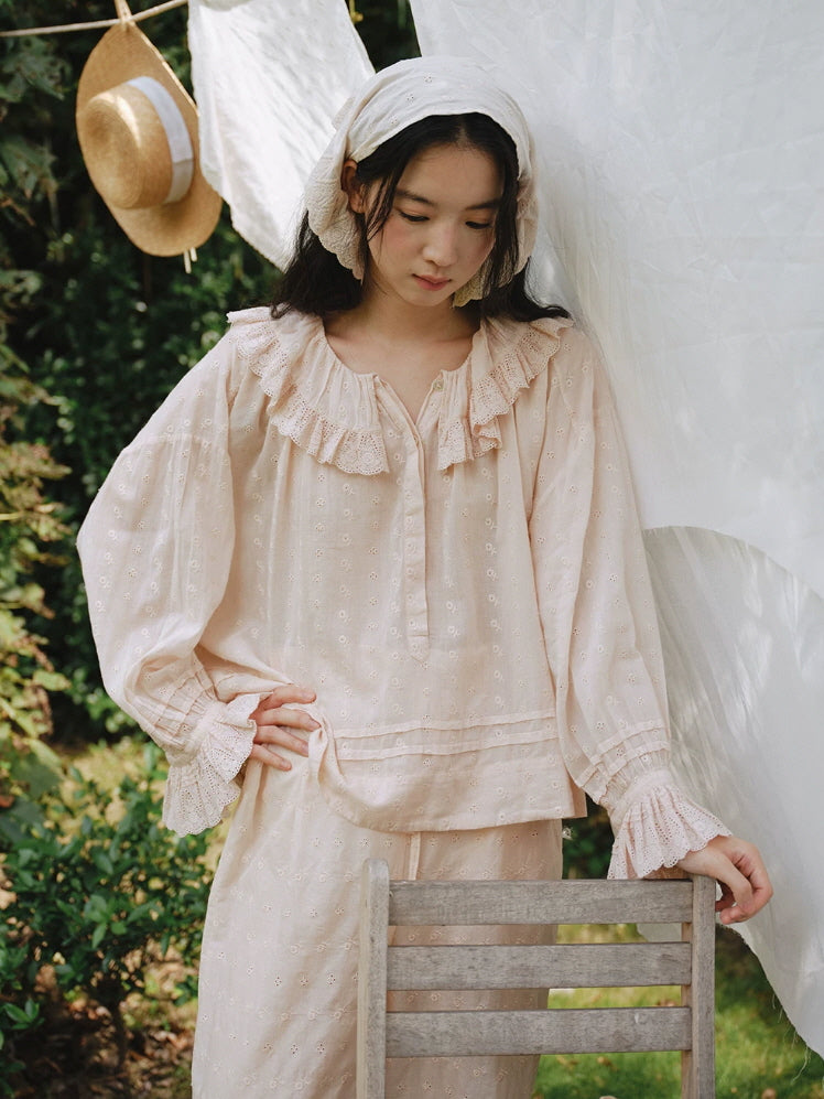Close up of blush pink pajama top with floral eyelet embroidery and scalloped lace ruffle collar