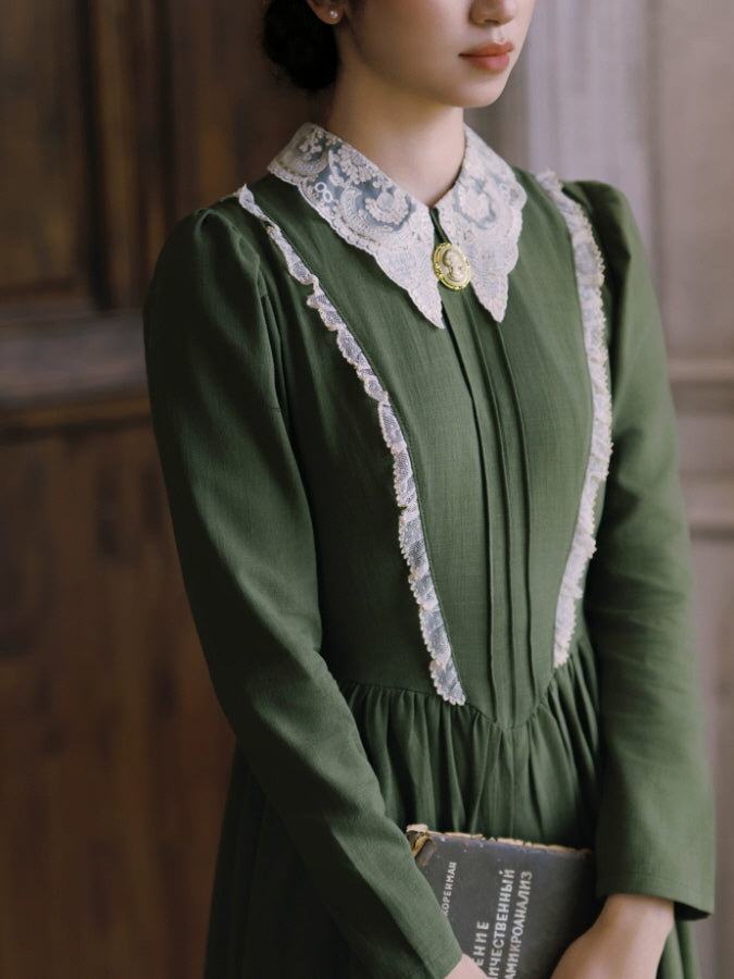 Green romantic cottagecore dress with flowing maxi skirt, lace details and elegant long sleeves