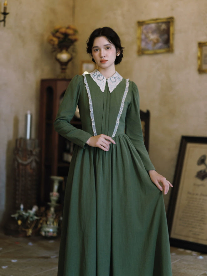 Elegant green long sleeve maxi dress with vintage lace collar and softly gathered waist in an antique interior