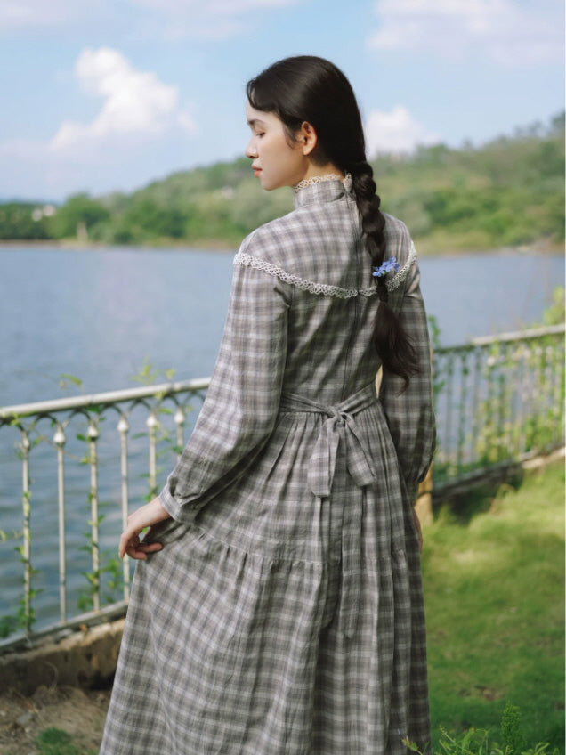 Back view of gray check cottagecore dress with lace shoulder detail, tie waist and flowing long skirt
