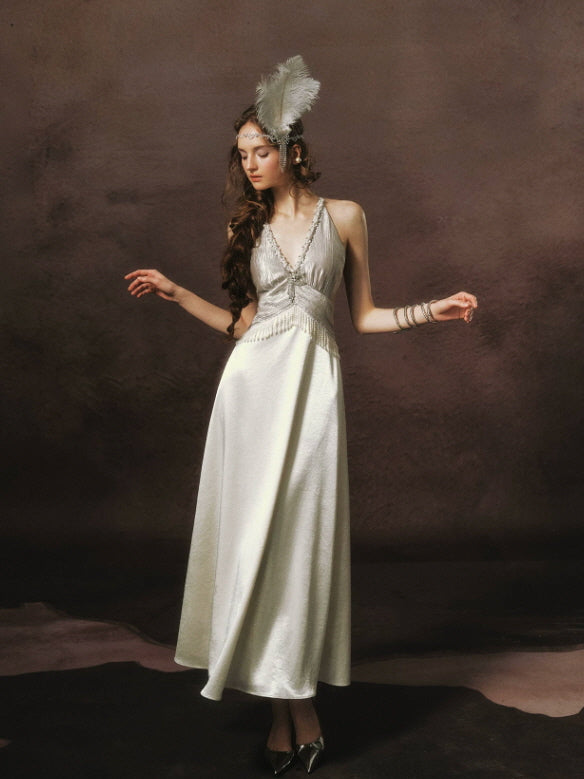 Full-length vintage glamour ivory maxi dress with a flowing satin skirt, pearl embellished bodice, and elegant feminine silhouette.
