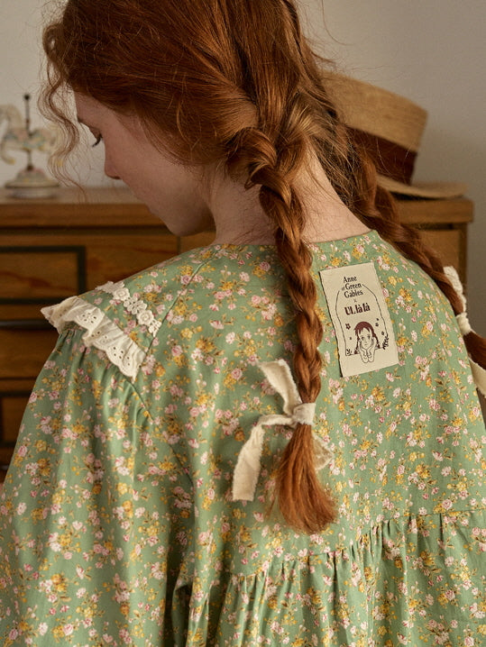 A close-up of the back of a green floral loungewear set, showcasing the Anne of Green Gables-themed label and charming lace bow details for a vintage-inspired look.