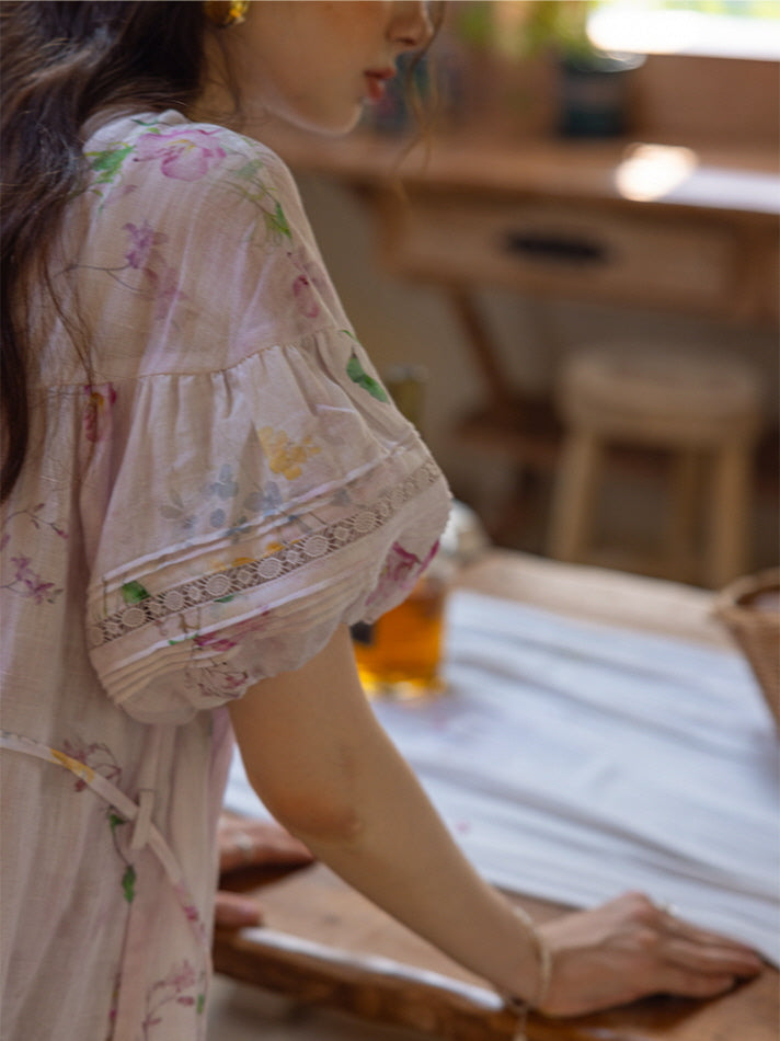 Close-up view of the sleeve detail of a soft lavender floral dress with delicate lace trim, showcasing gentle ruffles and floral prints.