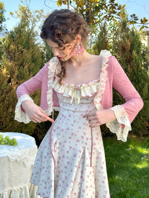 A romantic cottagecore-inspired dress paired with a delicate lace-trimmed pink cardigan, featuring floral accents and a soft vintage aesthetic. 
