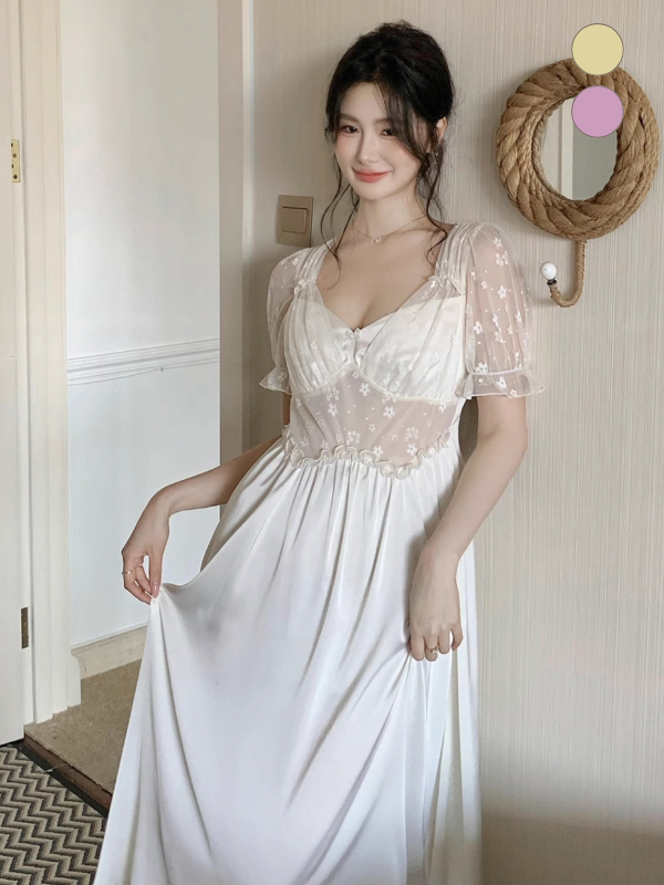 Model wearing a long ivory fairy princess nightgown with floral mesh sleeves and satin bodice, standing in a soft-lit vintage room with fairytale charm.
