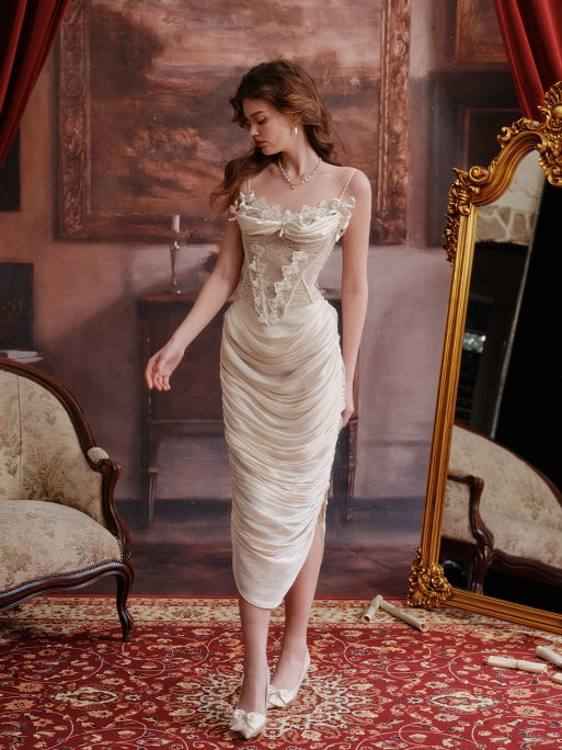 Romantic vintage outfit featuring a lace embroidered corset and soft ivory draped skirt, styled on a model walking gracefully across an antique carpeted room with a classical backdrop.
