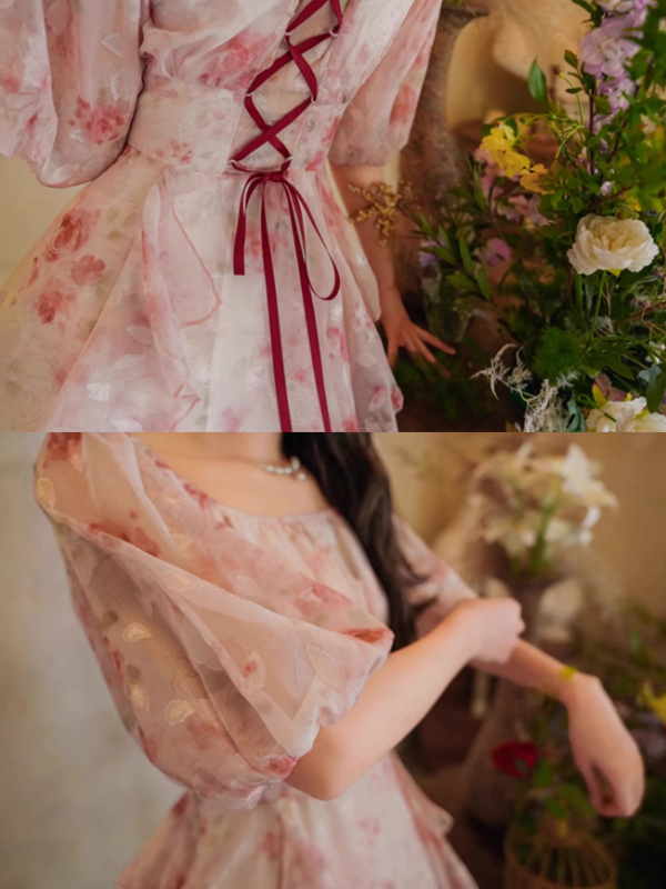 Detailed view of the floral dress's lace-up back and airy puff sleeves, capturing the vintage-inspired texture and romantic design.