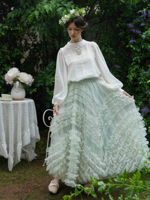 Wearing a white puff-sleeve blouse and layered mint ruffle skirt, the model poses gracefully in a vintage-inspired princesscore outfit.