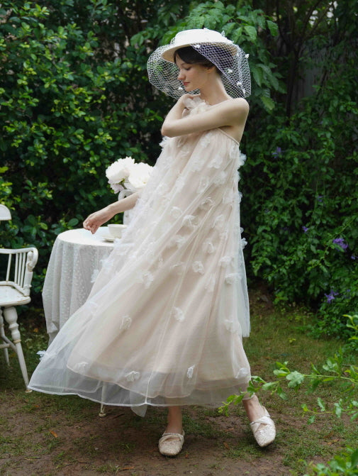 Model twirls gently in a flowing sheer dress with delicate floral appliqués, creating a romantic princesscore scene in a garden backdrop.